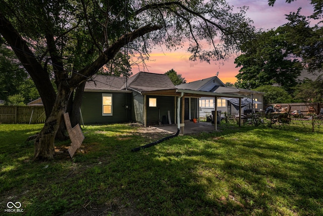 761 N Holmes Ave, Indianapolis, IN 46222 - back of house at dusk featuring a fenced backyard and a patio area