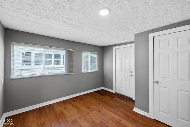 761 N Holmes Ave, Indianapolis, IN 46222 - unfurnished bedroom with a textured ceiling and dark wood-type flooring