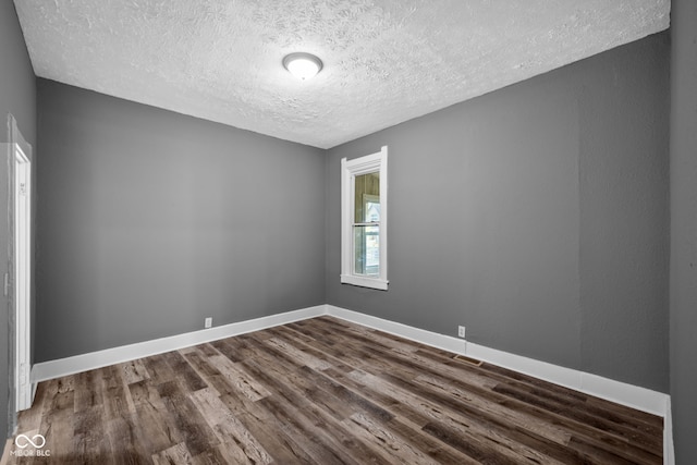 761 N Holmes Ave, Indianapolis, IN 46222 - empty room with a textured ceiling and dark wood finished floors