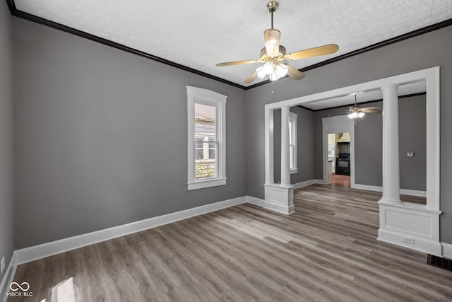 761 N Holmes Ave, Indianapolis, IN 46222 - spare room with ceiling fan, ornamental molding, a textured ceiling, wood finished floors, and ornate columns