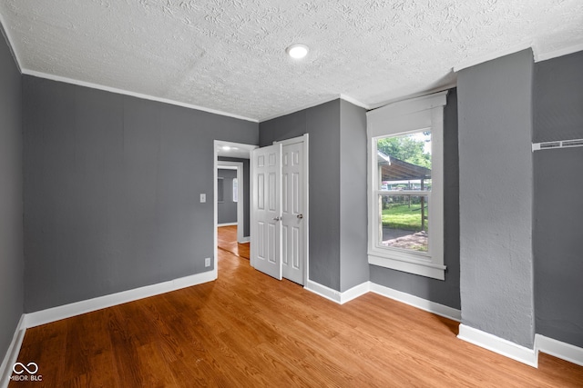 761 N Holmes Ave, Indianapolis, IN 46222 - unfurnished bedroom with a textured ceiling, wood finished floors, and ornamental molding