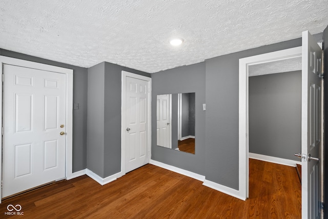 761 N Holmes Ave, Indianapolis, IN 46222 - unfurnished bedroom with a textured ceiling, wood finished floors, and a closet
