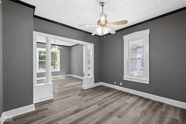 761 N Holmes Ave, Indianapolis, IN 46222 - spare room with crown molding, a ceiling fan, wood finished floors, a textured ceiling, and ornate columns