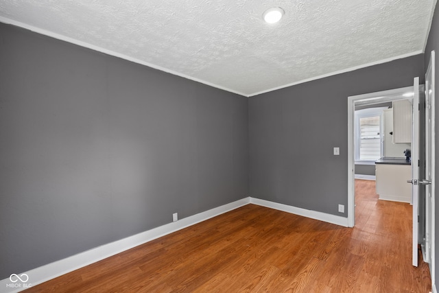 761 N Holmes Ave, Indianapolis, IN 46222 - empty room featuring a textured ceiling, wood finished floors, and ornamental molding