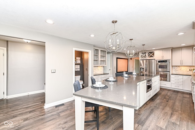 5826 Winding Way Ln, Indianapolis, IN 46220 - kitchen with appliances with stainless steel finishes, a chandelier, backsplash, a kitchen bar, and recessed lighting