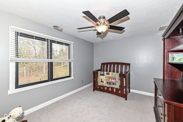 5826 Winding Way Ln, Indianapolis, IN 46220 - bedroom featuring light colored carpet, a textured ceiling, ceiling fan, and a nursery area