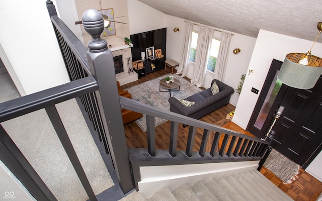 7612 Farm View Cir E, Indianapolis, IN 46256 - staircase featuring a textured ceiling, wood finished floors, and a fireplace