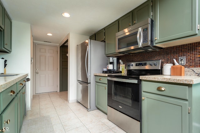 7612 Farm View Cir E, Indianapolis, IN 46256 - kitchen featuring green cabinetry, stainless steel appliances, light countertops, tasteful backsplash, and recessed lighting