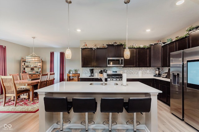 9806 Olympic Blvd, Pendleton, IN 46064 - kitchen featuring appliances with stainless steel finishes, light wood-style flooring, tasteful backsplash, light countertops, and recessed lighting