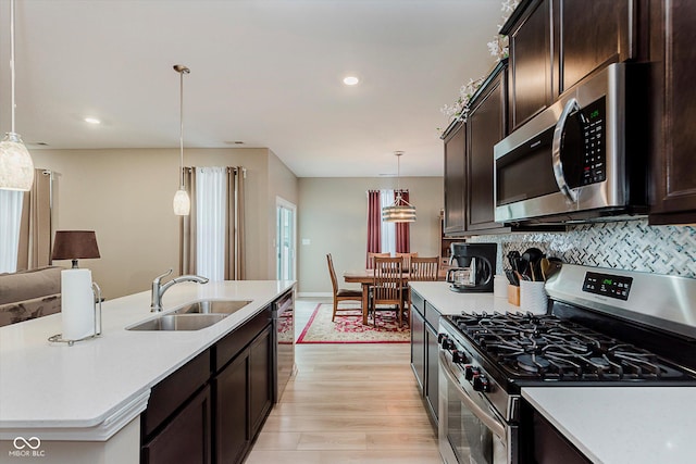 9806 Olympic Blvd, Pendleton, IN 46064 - kitchen featuring stainless steel appliances, dark brown cabinets, light countertops, light wood finished floors, and recessed lighting