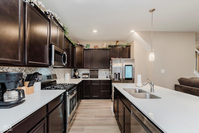 9806 Olympic Blvd, Pendleton, IN 46064 - kitchen with appliances with stainless steel finishes, light countertops, pendant lighting, dark brown cabinetry, and decorative backsplash