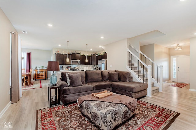 9806 Olympic Blvd, Pendleton, IN 46064 - living room featuring stairs, light wood-style floors, recessed lighting, and a chandelier