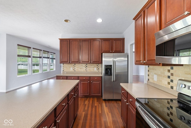 12997 Bartlett Dr, Fishers, IN 46037 - kitchen with stainless steel appliances, backsplash, dark wood-type flooring, light countertops, and recessed lighting