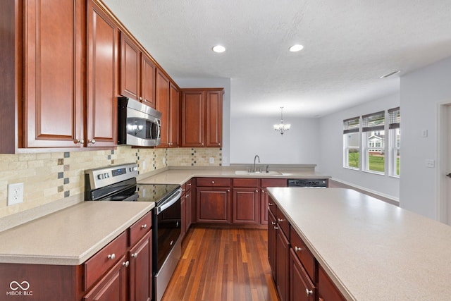 12997 Bartlett Dr, Fishers, IN 46037 - kitchen featuring stainless steel appliances, dark wood-style floors, a chandelier, recessed lighting, and light countertops