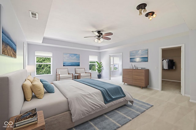12997 Bartlett Dr, Fishers, IN 46037 - bedroom with a raised ceiling, light carpet, and ceiling fan