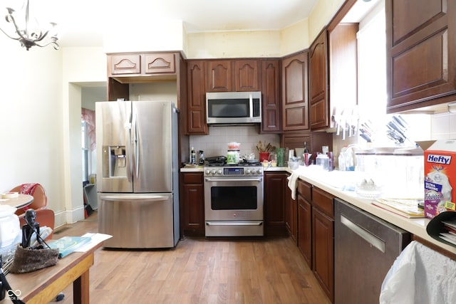 633 N E St, Greenfield, IN 46140 - kitchen with appliances with stainless steel finishes, light countertops, decorative backsplash, and light wood-style flooring
