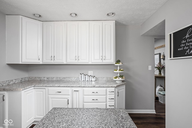 6429 Walnut Way, Brownsburg, IN 46112 - kitchen with white cabinets, dark wood-style floors, a textured ceiling, and light stone counters