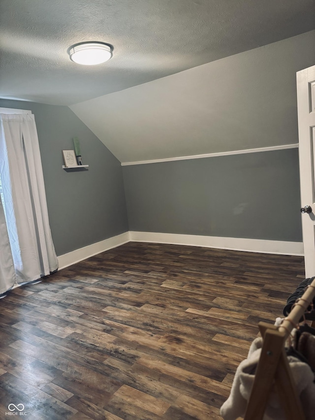 597 W Adams St, Franklin, IN 46131 - bonus room with dark wood-type flooring, vaulted ceiling, and a textured ceiling