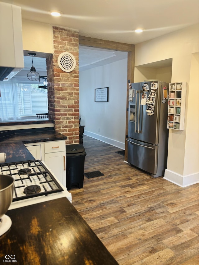597 W Adams St, Franklin, IN 46131 - kitchen with stainless steel fridge with ice dispenser, dark countertops, white cabinets, wood finished floors, and stovetop
