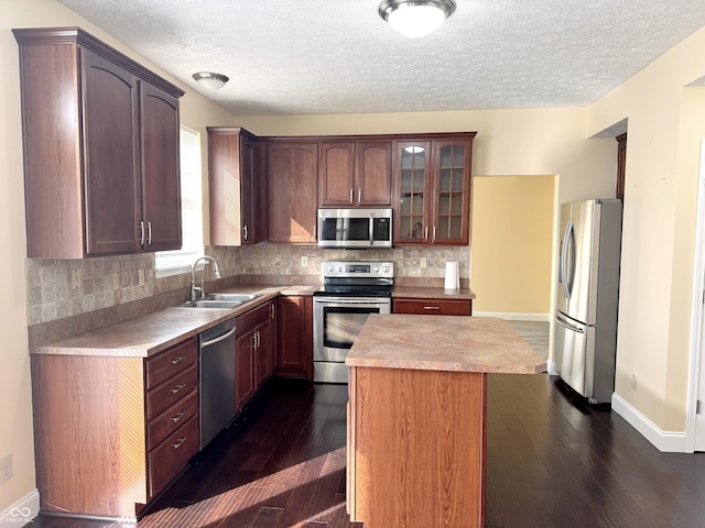 2444 Cole Branch Ct, Indianapolis, IN 46239 - kitchen featuring appliances with stainless steel finishes, light countertops, a center island, decorative backsplash, and a textured ceiling
