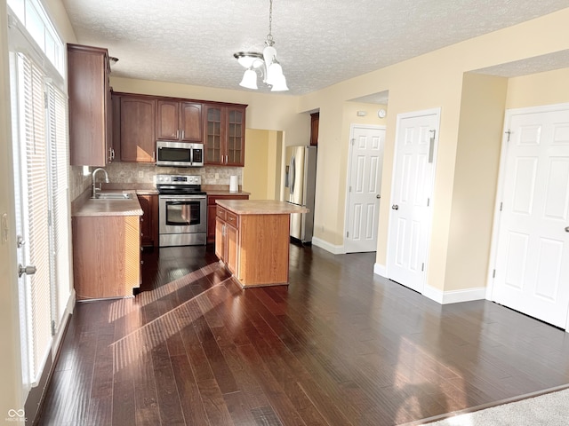 2444 Cole Branch Ct, Indianapolis, IN 46239 - kitchen with appliances with stainless steel finishes, light countertops, a chandelier, tasteful backsplash, and dark wood finished floors
