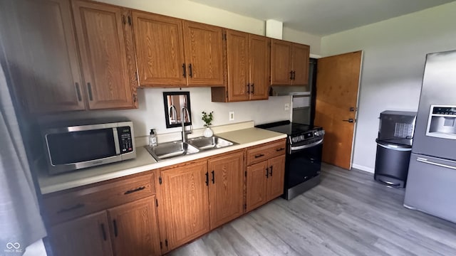 336 Brookside Ln, Plainfield, IN 46168 - kitchen featuring stainless steel appliances, light wood finished floors, light countertops, under cabinet range hood, and brown cabinetry