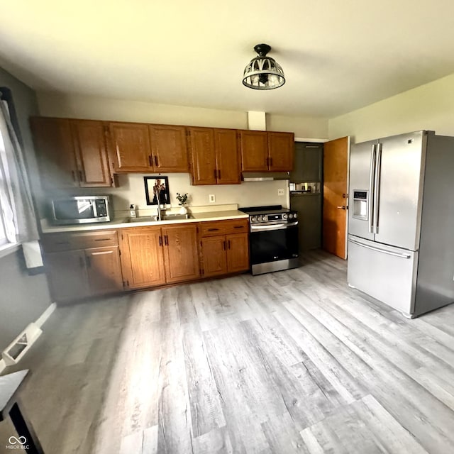 336 Brookside Ln, Plainfield, IN 46168 - kitchen with appliances with stainless steel finishes, light wood-style flooring, under cabinet range hood, and light countertops