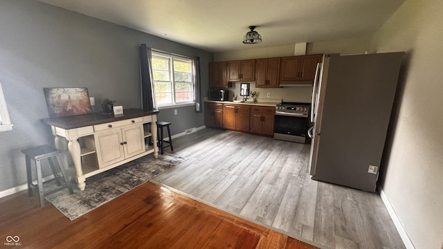 336 Brookside Ln, Plainfield, IN 46168 - kitchen with stainless steel appliances, light wood-type flooring, under cabinet range hood, and open shelves