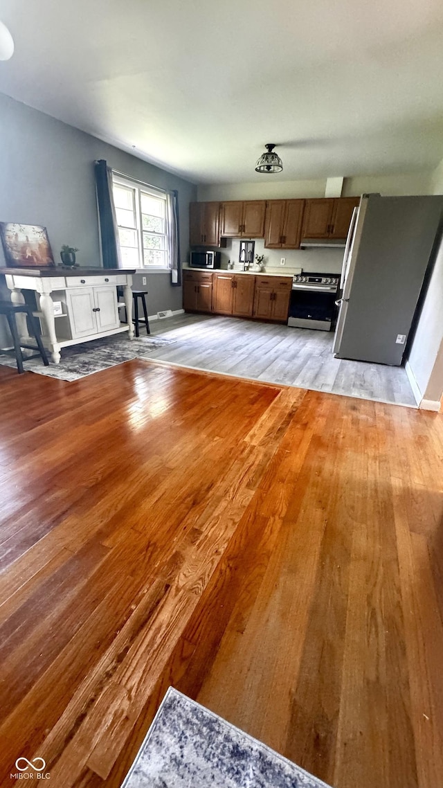 336 Brookside Ln, Plainfield, IN 46168 - kitchen with appliances with stainless steel finishes, light wood-style floors, light countertops, and brown cabinets