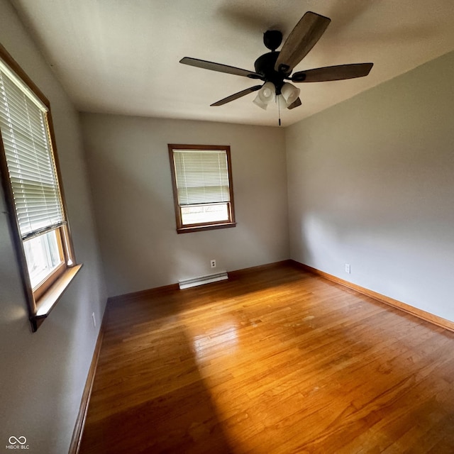 336 Brookside Ln, Plainfield, IN 46168 - empty room featuring plenty of natural light, wood finished floors, a baseboard radiator, and ceiling fan