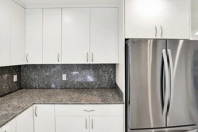 944 Briar Patch Ln, Greenwood, IN 46142 - kitchen featuring freestanding refrigerator, tasteful backsplash, white cabinets, and dark stone countertops