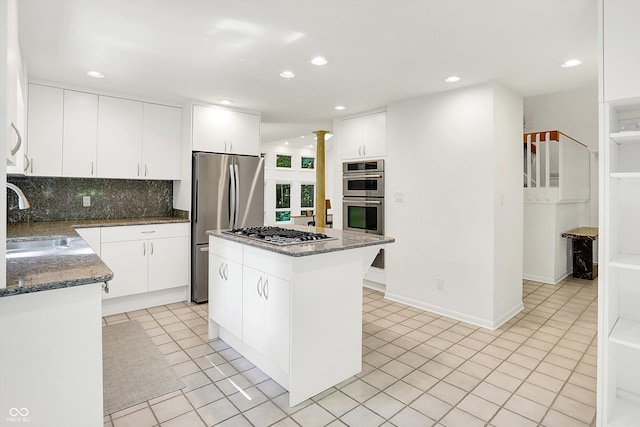944 Briar Patch Ln, Greenwood, IN 46142 - kitchen with appliances with stainless steel finishes, backsplash, a center island, dark stone countertops, and recessed lighting