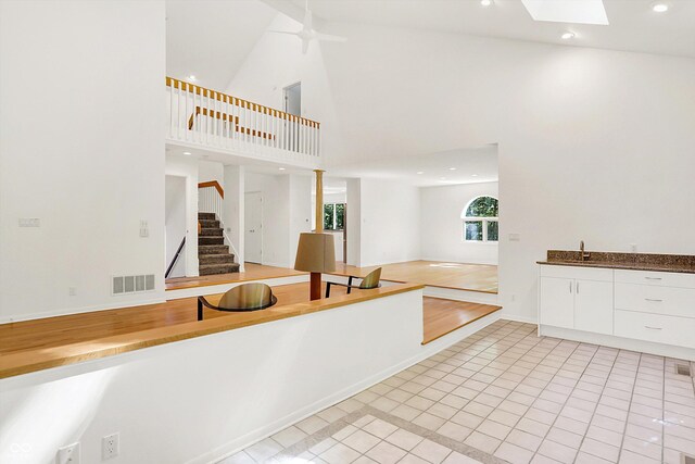 944 Briar Patch Ln, Greenwood, IN 46142 - kitchen featuring high vaulted ceiling, white cabinets, light tile patterned floors, recessed lighting, and a skylight