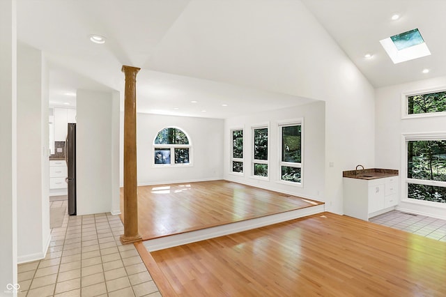 944 Briar Patch Ln, Greenwood, IN 46142 - unfurnished living room with light tile patterned flooring, a skylight, high vaulted ceiling, ornate columns, and recessed lighting