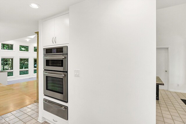 944 Briar Patch Ln, Greenwood, IN 46142 - kitchen featuring a warming drawer, double oven, white cabinetry, light tile patterned floors, and recessed lighting