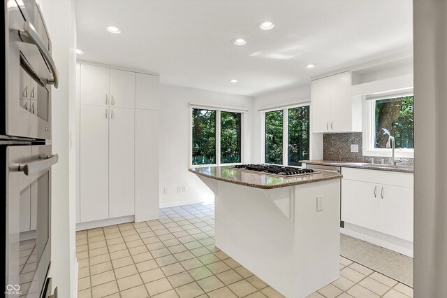 944 Briar Patch Ln, Greenwood, IN 46142 - kitchen featuring stainless steel gas cooktop, tasteful backsplash, stone counters, recessed lighting, and white cabinetry