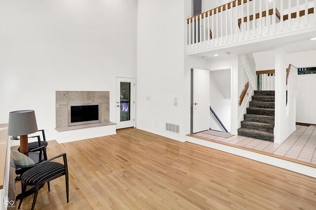 944 Briar Patch Ln, Greenwood, IN 46142 - living room featuring wood finished floors, a towering ceiling, stairway, and a premium fireplace