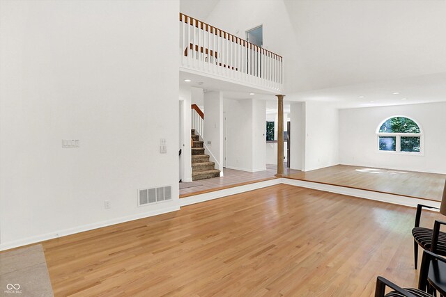 944 Briar Patch Ln, Greenwood, IN 46142 - unfurnished living room with light wood-style flooring, stairs, a towering ceiling, and recessed lighting