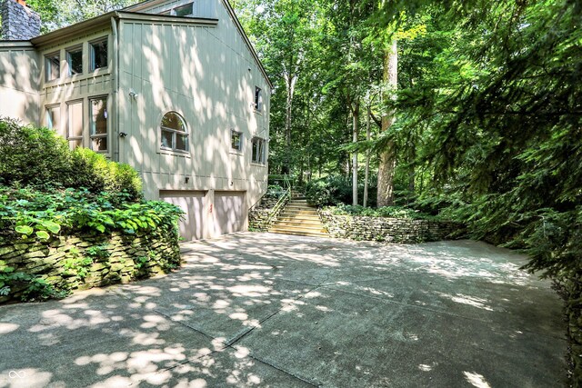 944 Briar Patch Ln, Greenwood, IN 46142 - view of side of property featuring driveway, an attached garage, a chimney, and stairway