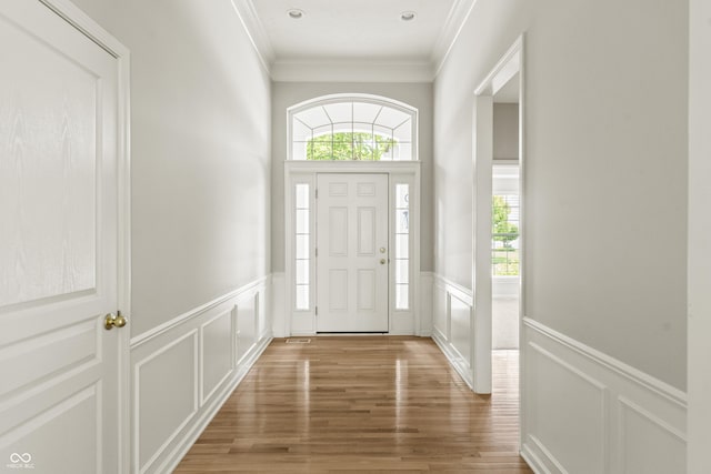 13172 Duval Dr, Fishers, IN 46037 - entryway featuring a decorative wall, wainscoting, ornamental molding, and light wood-type flooring