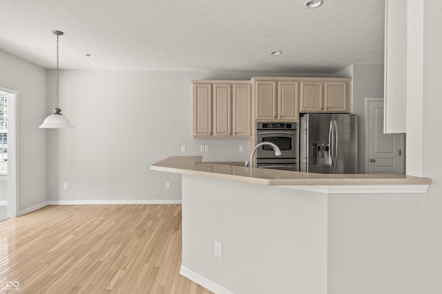 13172 Duval Dr, Fishers, IN 46037 - kitchen featuring appliances with stainless steel finishes, light wood-style floors, recessed lighting, pendant lighting, and cream cabinetry
