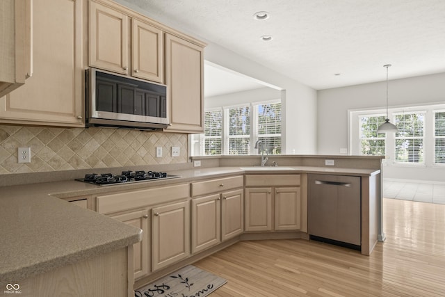 13172 Duval Dr, Fishers, IN 46037 - kitchen with stainless steel appliances, a peninsula, light countertops, backsplash, and recessed lighting