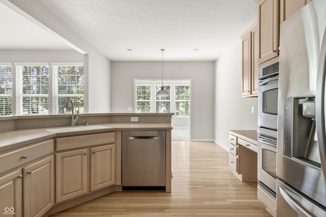 13172 Duval Dr, Fishers, IN 46037 - kitchen featuring stainless steel appliances, light wood-type flooring, hanging light fixtures, and light brown cabinetry