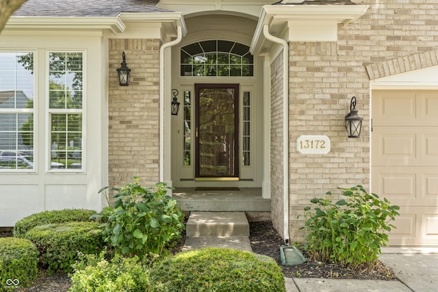 13172 Duval Dr, Fishers, IN 46037 - doorway to property featuring brick siding, a garage, and a shingled roof