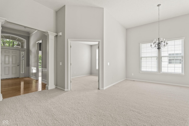 13172 Duval Dr, Fishers, IN 46037 - foyer entrance featuring carpet floors, high vaulted ceiling, a chandelier, and ornate columns