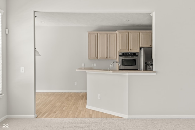 13172 Duval Dr, Fishers, IN 46037 - kitchen with appliances with stainless steel finishes, cream cabinetry, light wood finished floors, and light countertops