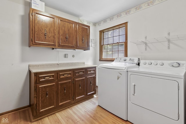 8439 Goldfinch Cir, Indianapolis, IN 46256 - laundry room with cabinet space, washer and clothes dryer, and light wood-style flooring