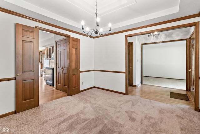 8439 Goldfinch Cir, Indianapolis, IN 46256 - empty room with a tray ceiling, a chandelier, carpet flooring, ornamental molding, and wood finished floors