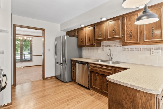 8439 Goldfinch Cir, Indianapolis, IN 46256 - kitchen with appliances with stainless steel finishes, light wood-style floors, light countertops, decorative backsplash, and pendant lighting
