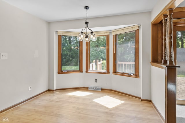 8439 Goldfinch Cir, Indianapolis, IN 46256 - unfurnished dining area featuring light wood-style flooring, healthy amount of natural light, and a chandelier